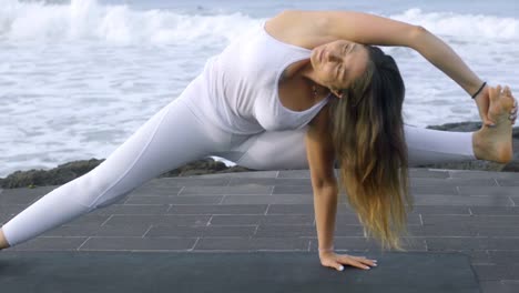 Mujer-flexible-haciendo-Yoga-en-muelle