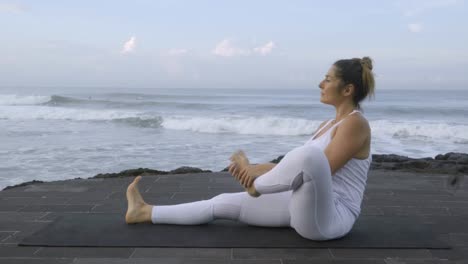 Mature-Flexible-Woman-Practicing-Yoga-on-Coastline