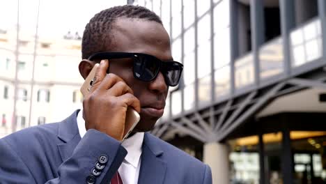 Confident-and-succesful--black-business-man-in-the-street-taking-by-phone