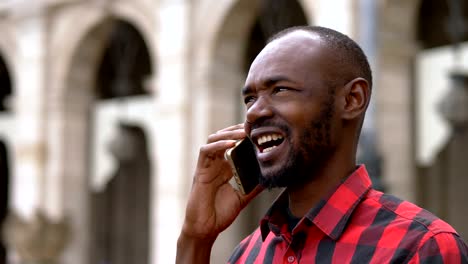 Atractivo-negro-africano-joven-hablando-por-teléfono-en-el-street