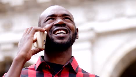 Attractive-black---man-talking-by-phone,looking-up---outdoor