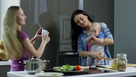 Mujer-tomando-foto-de-mujer-pareja-con-bebé