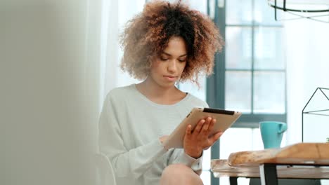 Lächelt-glücklich-Afro-Amerikanerin-mit-Tablet-pc-zu-Hause.