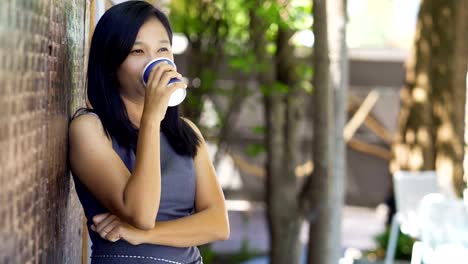 Asian-women-drink-hot-coffee-in-a-coffee-shop-happily.