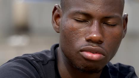 Young-African-immigrant-staring-at-the-camera.-sadness,-poverty--close-up