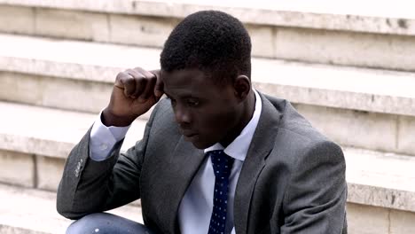 portrait-of-Thoughtful-worried-young-black-african-business-man-alone-in-the-city