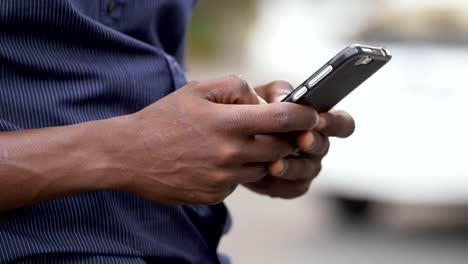 manos-del-joven-negro-africano-escribiendo-en-smartphone-comunicación,-juventud,-tecnología