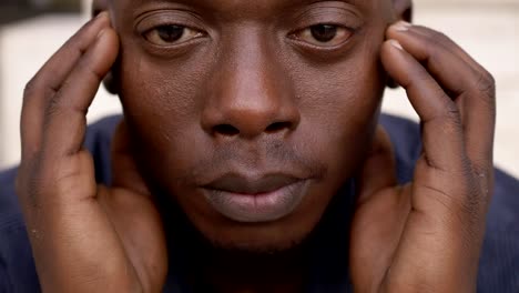 thoughtful-young-black-man-raising-his-head-and-staring-at-camera--close-up