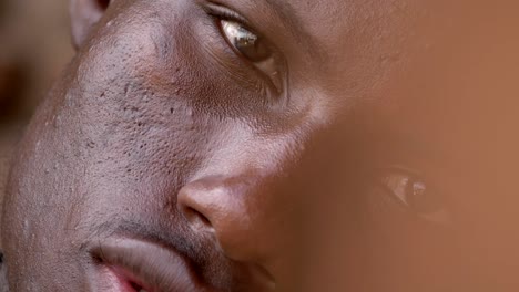 close-up-portrait-of-Depressed-sad-black-american-young-man-leaning-against-wall-staring-at-camera