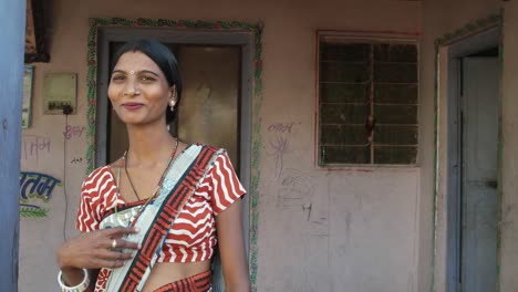 Beautiful-Indian-newly-married-young-woman-in-traditional-costumes-in-domestic-setting-costume-looks-happy-laughs-smiles-joy-interior-indoor-home-house-porch-mid-shot-lock-down-static--curious