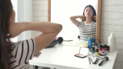 Frau-fesselt-ihr-Haar-vor-dem-Spiegel