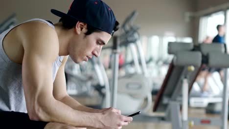 A-shirtless-guy-at-the-gym,-trains-his-body-to-stay-fit-and-have-defined-muscles.-The-athlete-raises-heavy-weights-and-fatigue.