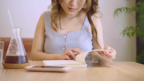 Junge-chinesische-Studentin-mit-Büchern-In-der-Bibliothek