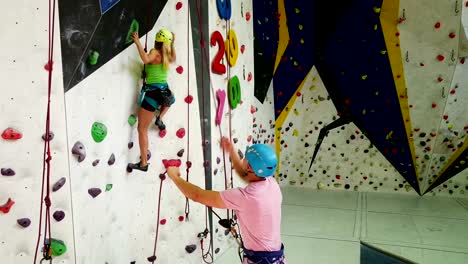 Sporty-couple-of-climbers--at-bouldering-gym