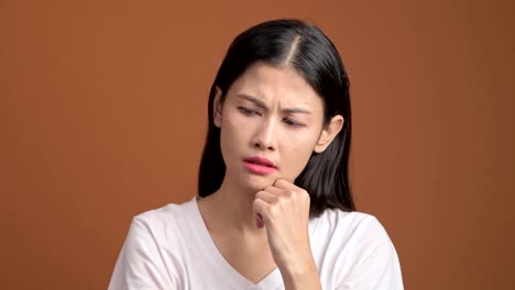 Thinking-woman-isolated.-Portrait-of-asian-woman-in-white-t-shirt-thinking-hard-and-excited-to-find-a-solution,-looking-at-camera.