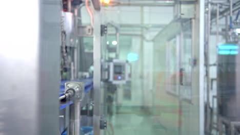 Woman-industrial-engineer-at-work-in-factory.-Beautiful-young-chinese-engineer-working-in-large-factory.-With-safety-helmet-and-jacket.-High-tech-automatic-machine-in-background.