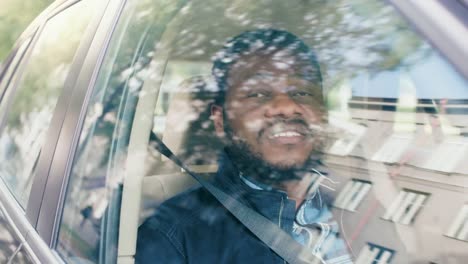 Handsome-Young-Black-Man-Rides-on-a-Passenger-Seat-of-a-Car,-Looks-in-Wonder-out-of-the-Window.-Suburban-Area-Reflects-in-the-Window.-Camera-Mounted-outside-Moving-Car.