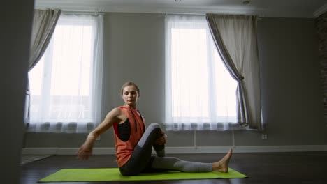 Mujer-haciendo-sentado-Twist-de-Yoga-en-casa