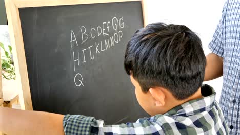 Father-teaches-children-boy-to-writing-the-chalkboard.-Education-concept.