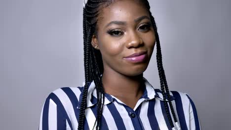 confident-sight-of-african-girl-close-up-at-camera-on-the-gray-background-in-motion-relaxed