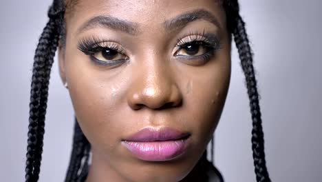 close-up-portrait-of-beautiful-african-girl-looking-at-camera-with-proud-and-confidence-on-gray-foil