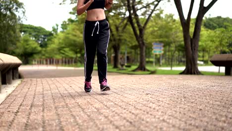 Mujer-bonita-joven-trotar-con-felicidad-en-el-ejercicio-al-aire-libre