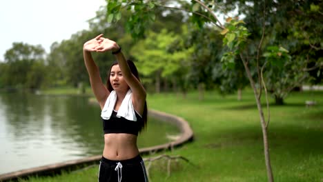 Junge,-weibliche-Muskeln-dehnen-vor-dem-Joggen-im-Naturpark