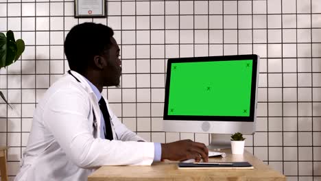 Junge-afrikanische-Ärztin-suchen-auf-Monitor-seines-Computers.-Weißes-Display