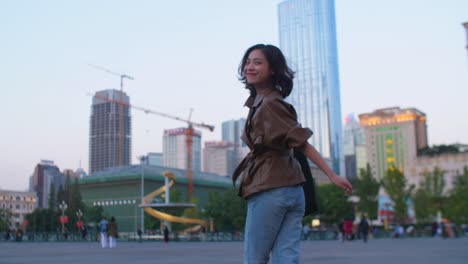 Pretty-young-asian-woman-running-in-the-city-at-evening,-4k