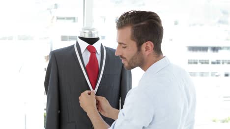 Handsome-tailor-measuring-suit-on-mannequin