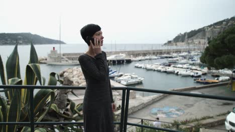 Young-woman-tourist-talks-on-the-mobile-phone-at-the-seaside