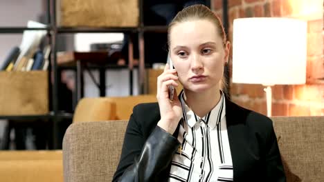 Mujer-de-negocios-hablando-por-teléfono-inteligente