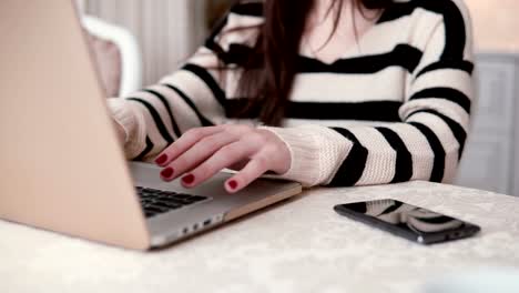 closeup-hands-of-young-woman-uses-laptop-in-a-bright-dining