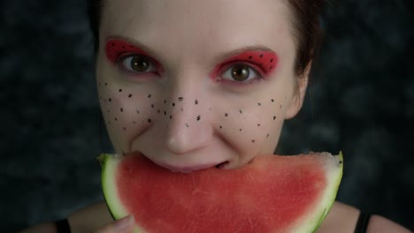 4-k-Aufnahme-einer-Frau-mit-bunten-Make-up-eine-Wassermelone-essen