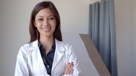 Porträt-des-weiblichen-Arzt-trägt-weiße-Mantel-im-Prüfungsraum