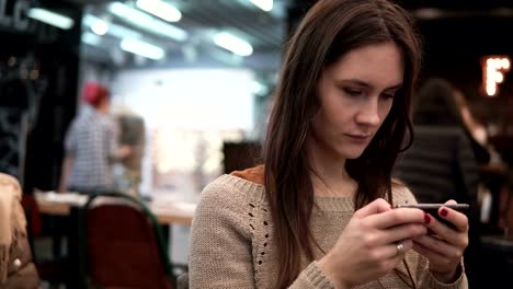 Closeup-portrait.-Woman-using-her-smartphone-touchscreen-device-in-modern-cafe-4k