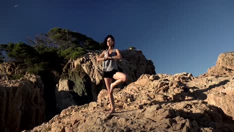 Mädchen-beim-Yoga-auf-einer-Klippe