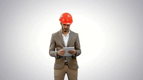 Young-architect-in-helmet-holding-tablet-and-showing-thumb-up-on-white-background