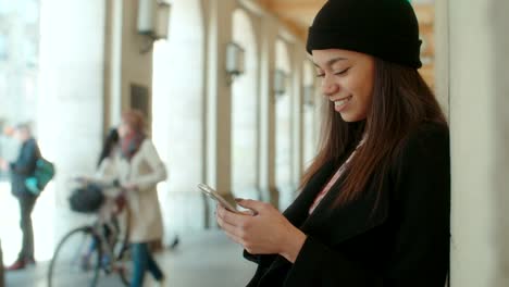 Portrait-of-young-African-American-woman-using-phone,-outdoors.