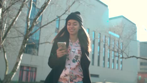 Portrait-of-young-African-American-woman-using-phone,-outdoors.