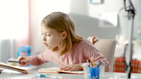 Smart-Little-Girl-Does-Homework-in-Her-Room.