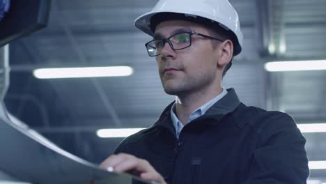 Engineer-in-Hard-Hat-Setting-Up-CNC-Machine-at-the-Factory