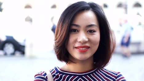 Young-Asian-Woman-In-City-at-day,-smile-happy-face-portrait