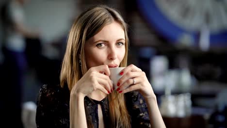 Lovely-girl-with-coffee-cup.-Young-beautiful-female-sitting-in-cafe-with-cup-of-coffee