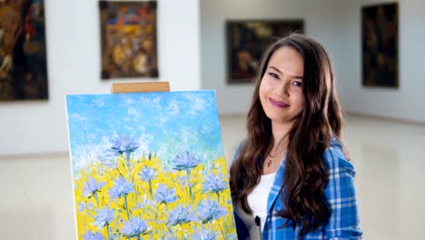 The-close-up-portrait-of-the-girl-standing-near-the-painting.-4K.