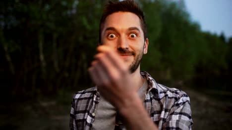 Portrait-of-young-smiling-man-with-sparkler-celebrating-at-beach-party