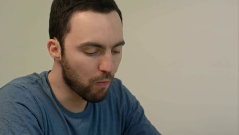 Young-man-drinking-tea-and-talking-casually-on-the-phone