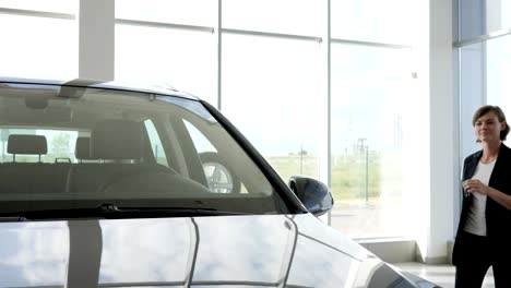 Portrait-owner-car,-woman-smiles-and-shows-in-hands-key-to-new