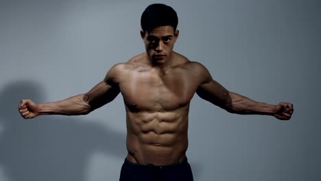 Fitness-Modell-zeigt-seinen-muskulösen-Oberkörper-2
