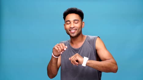 Young-happy-african-man-dancing-over-blue-background.